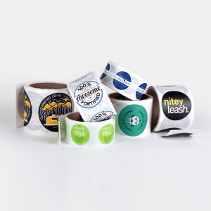 Rolls of colorful stickers with various designs and logos.