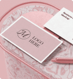 Elegant pink business card on a patterned surface with a pen.