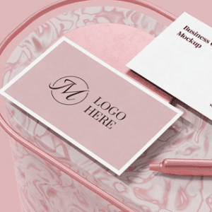 Elegant pink business card on a patterned surface with a pen.