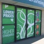 Storefront displays signs promoting lower prices and higher standards.