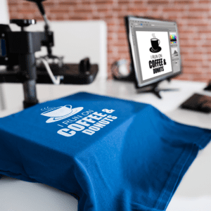 Blue coffee-themed t-shirt displayed on a printing machine.