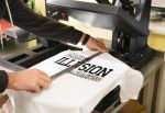 Person printing a custom design on a white T-shirt using a heat press machine.